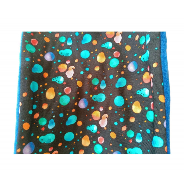 Pieza plana (borde azul): Pieza plana de la braga Manchas Azul con manchas multicolor y borde visto.