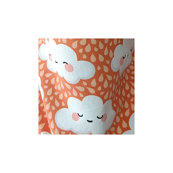 Tela estampada de nubes sonrientes sobre fondo naranja, detalle del diseño.