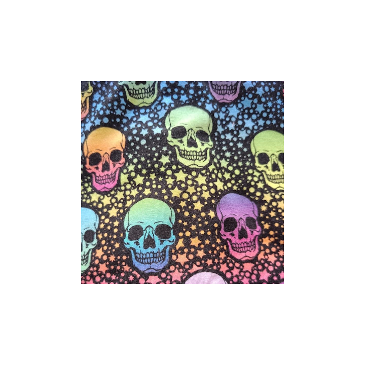 Detalle del tejido estampado con calaveras fluor en tonos vivos sobre fondo negro.