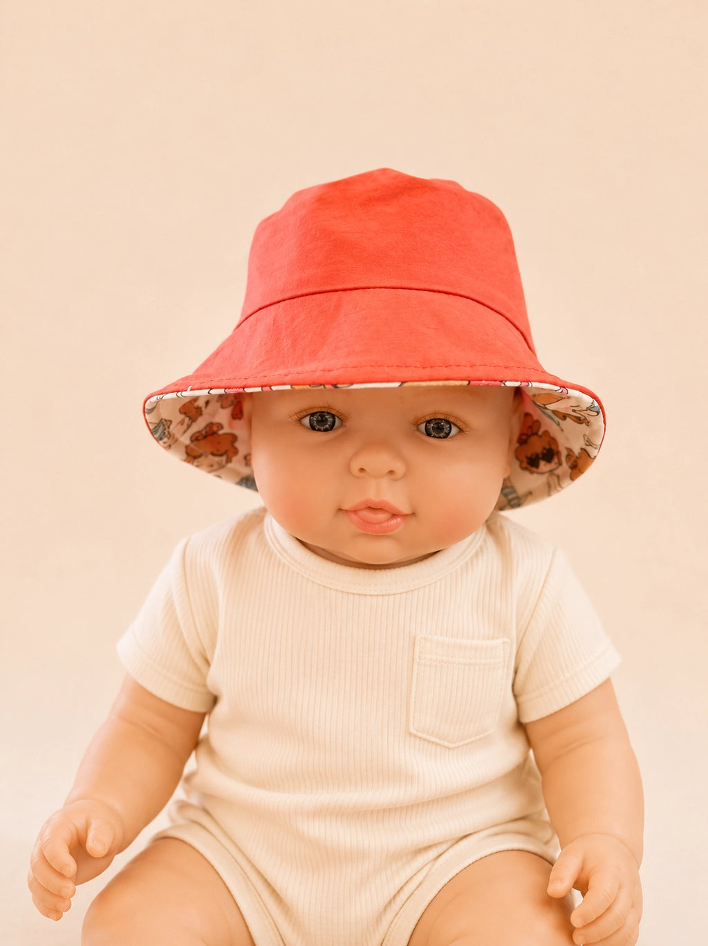 Gorrito de pescador reversible para bebé con reverso rojo y estampado de vacaciones