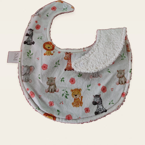 Babero impermeable 0–6 meses Animalitos de la sabana con una pata doblada para mostrar el rizo de algodón blanco roto
