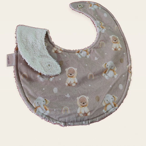 Babero impermeable 0–6 meses Animalitos del Ártico con una pata doblada para mostrar el rizo de algodón blanco roto