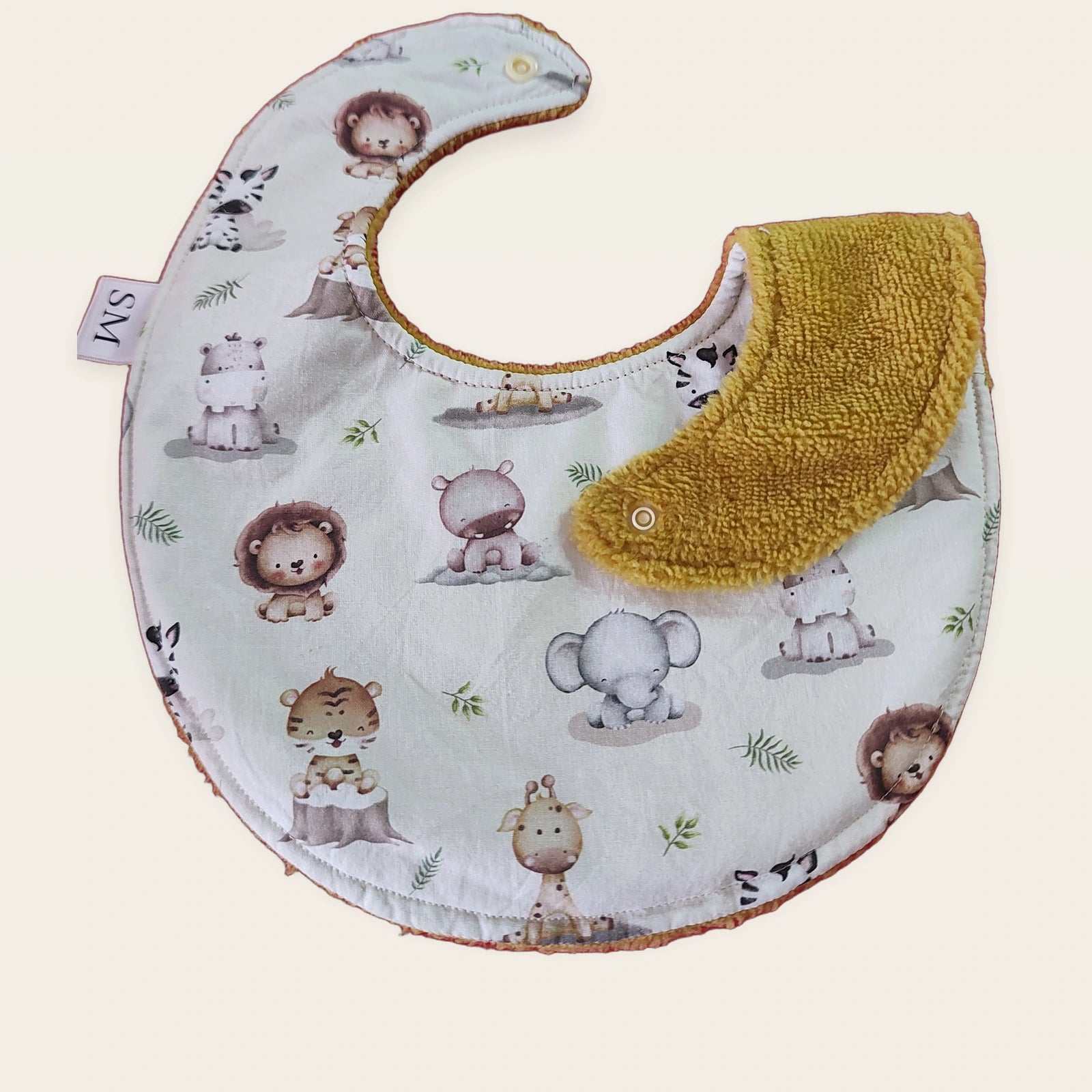Babero impermeable 0–6 meses Animalitos del bosque con una pata doblada para mostrar el rizo de bambú mostaza