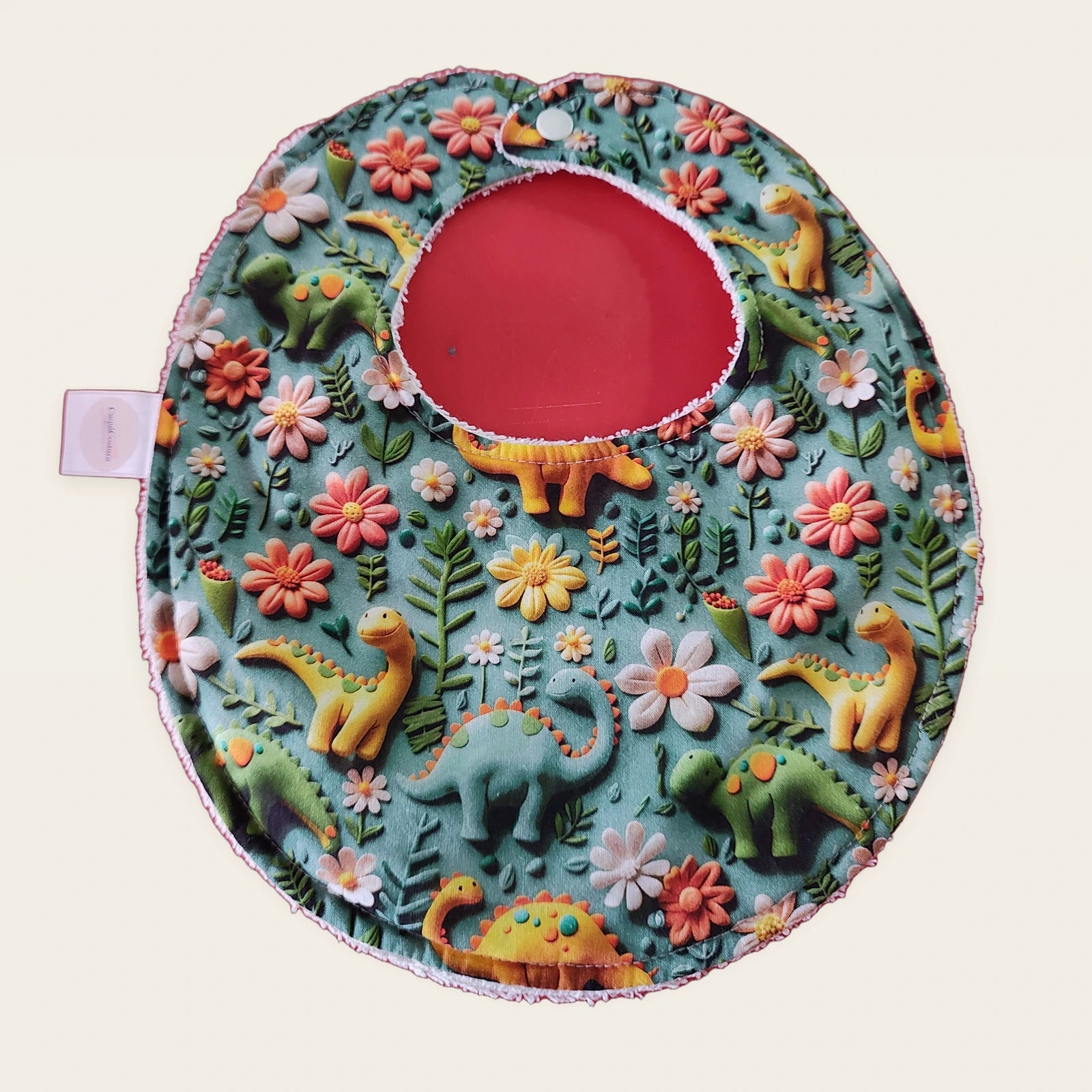 Babero impermeable 0–6 meses Dinosaurios y flores azul 3D con rizo de algodón blanco roto, vista frontal