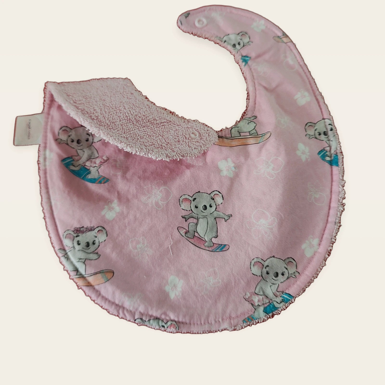 Babero impermeable 0–6 meses Koalas surferos con una pata doblada para mostrar el rizo de bambú rosa [Variant: Rosa]