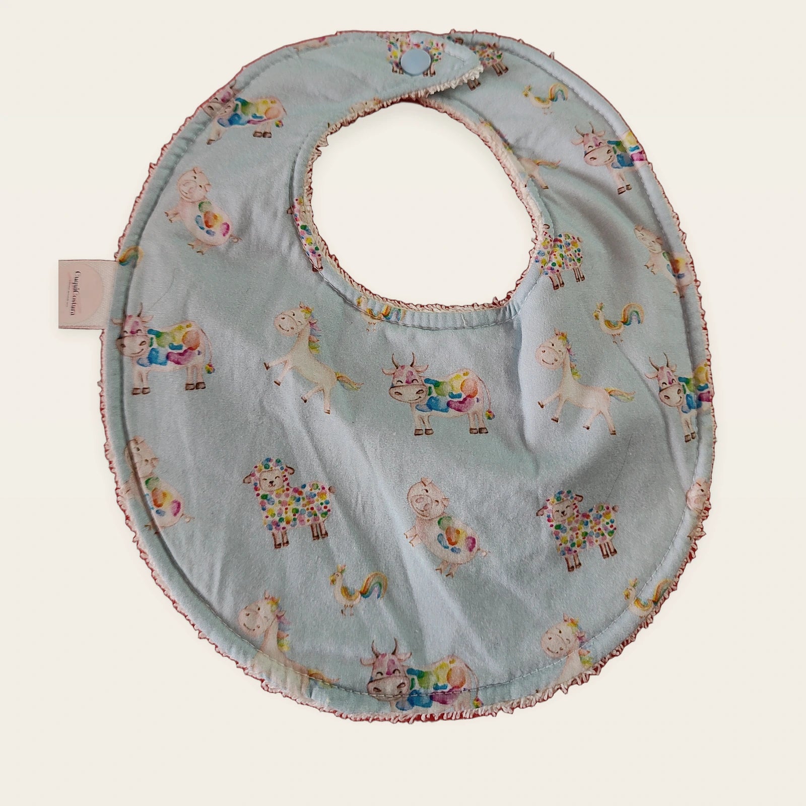 Babero impermeable 0–6 meses Ovejitas arcoíris con rizo de algodón blanco roto, vista frontal