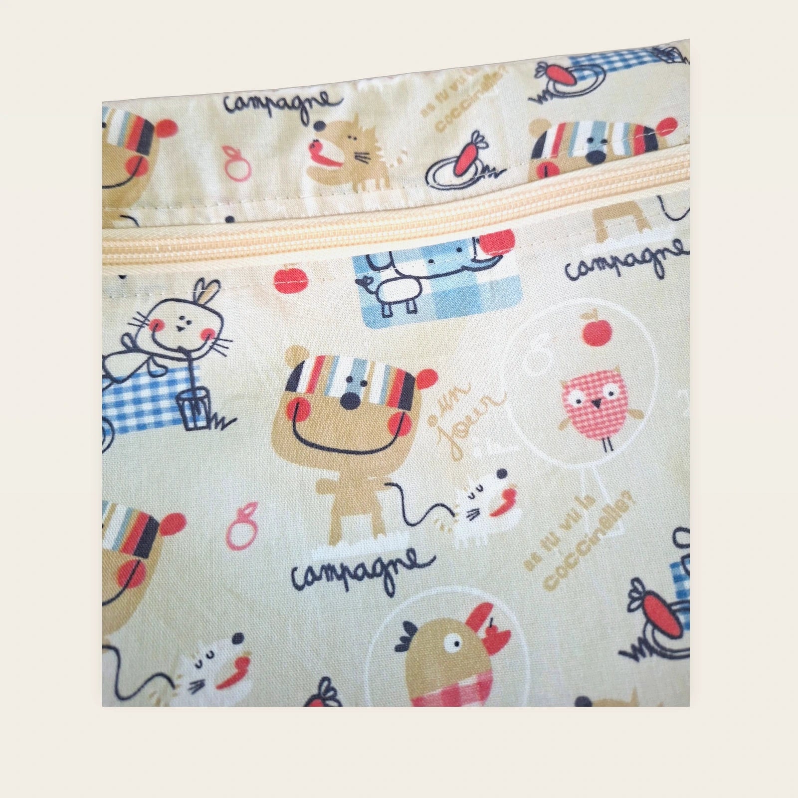 Detalle frontal de la cremallera beige de la bolsa impermeable Animalitos franceses