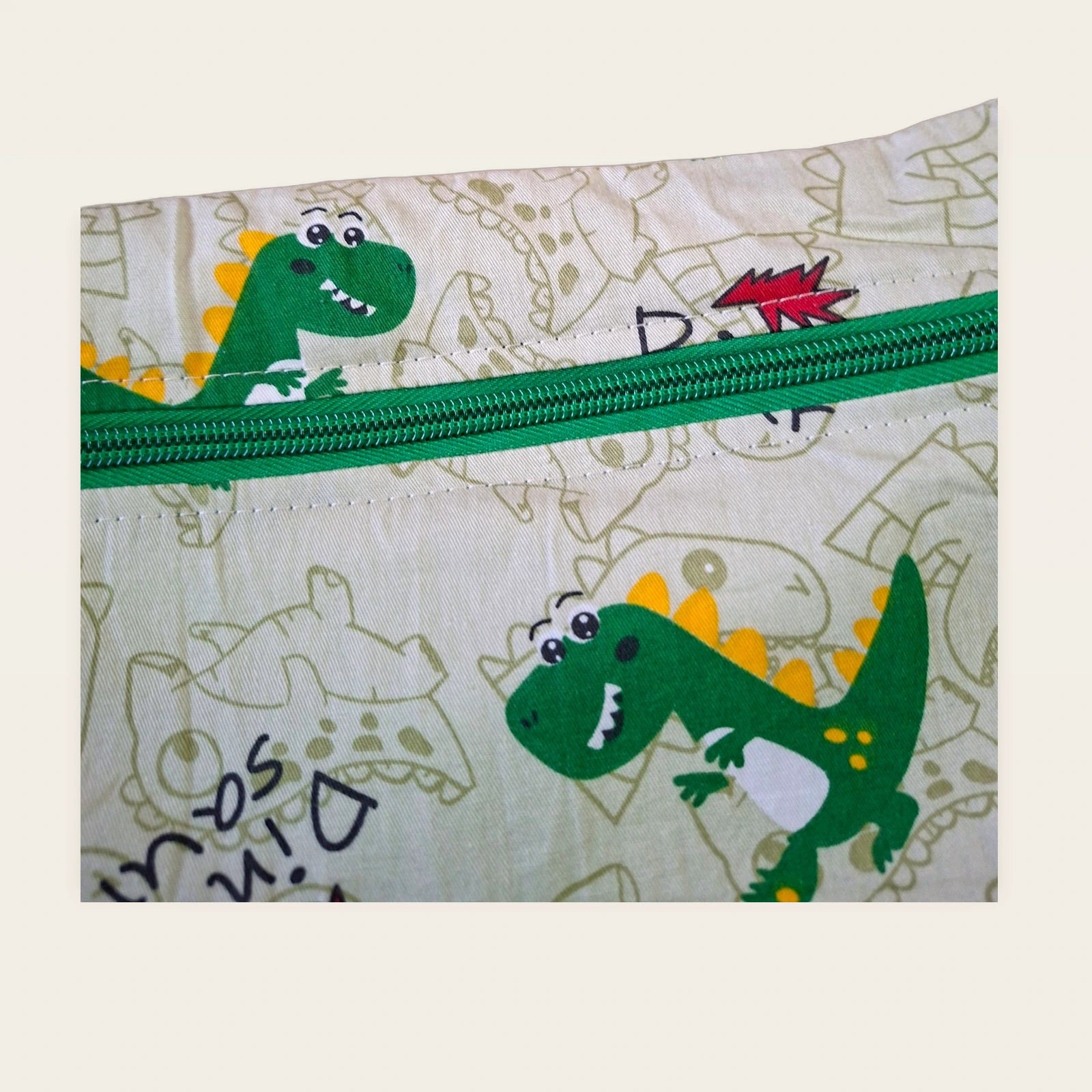 Detalle frontal de la cremallera verde de la bolsa impermeable Dinosaurios verdes