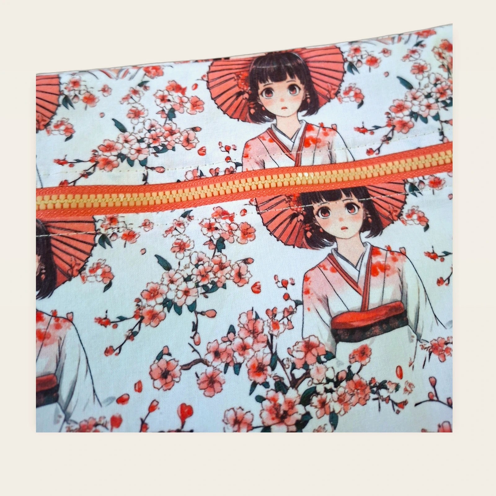 Detalle frontal de la cremallera amarilla y roja de la bolsa impermeable Geishas y cerezos