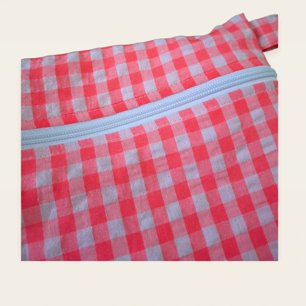 Detalle frontal de la cremallera blanca de la bolsa impermeable Vichy rosa flúor