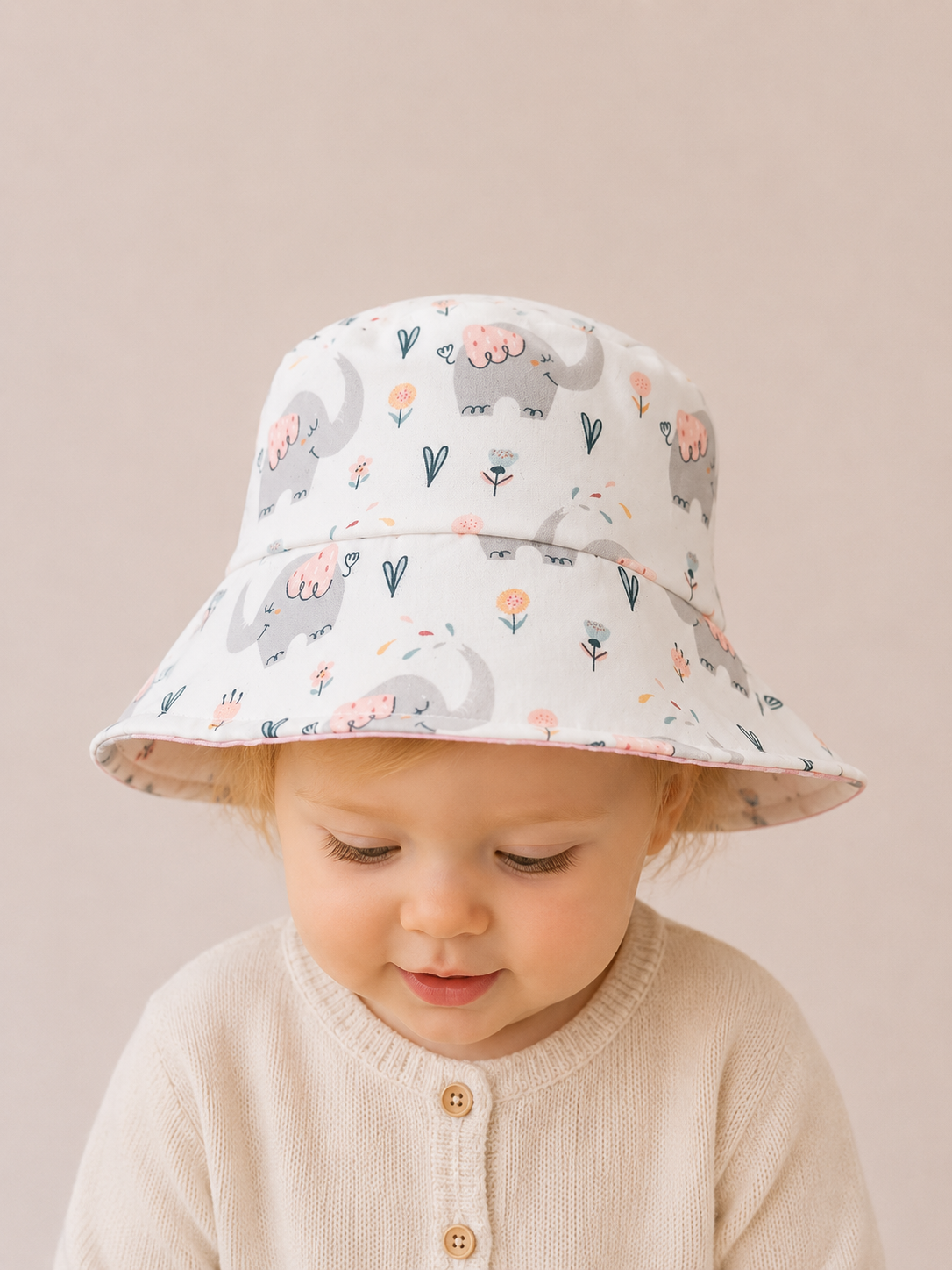 Gorrito reversible infantil con estampado de elefantes y reverso rosa de topitos [Variant: Topitos rosa]