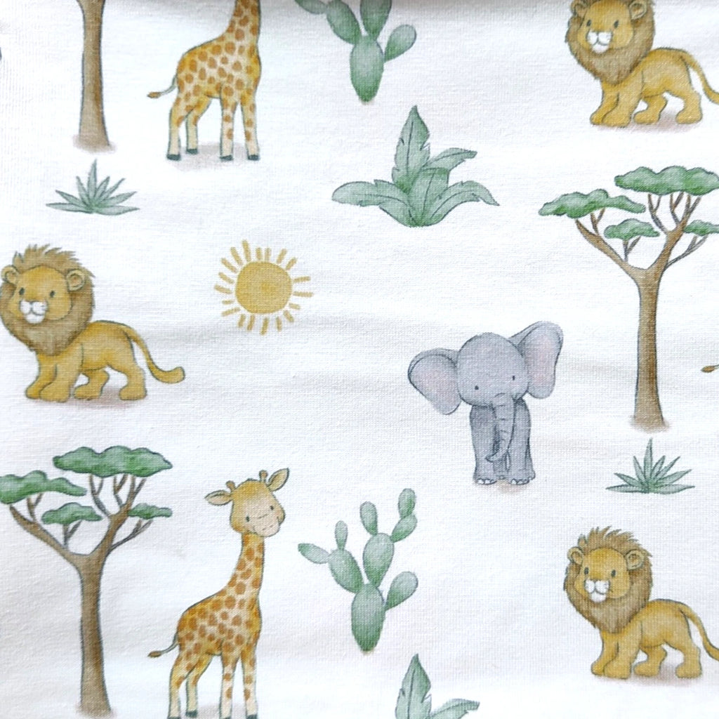 Detalle del estampado de animalitos de la sabana y baobabs en el tejido de punto de una braga de cuello infantil