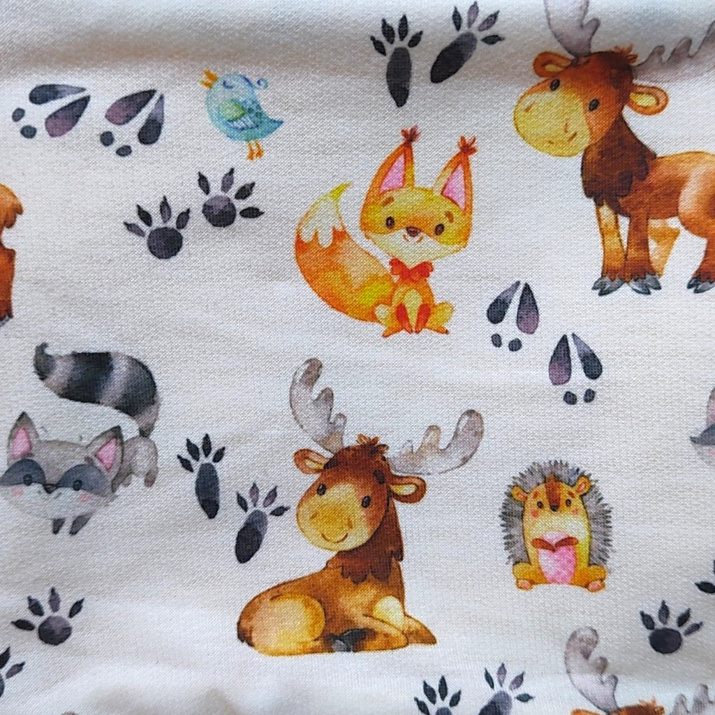 Detalle del estampado de animalitos y huellas en el tejido de punto de una braga de cuello infantil