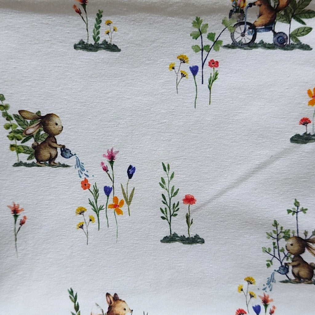 Detalle del estampado de conejitos regando en el tejido de punto de una braga de cuello infantil