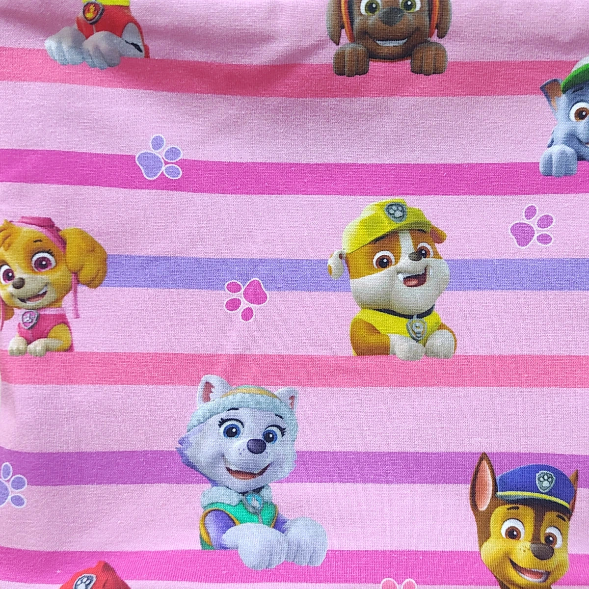 Detalle del estampado de perretes sobre rayas rosas en el tejido de punto de una braga de cuello infantil