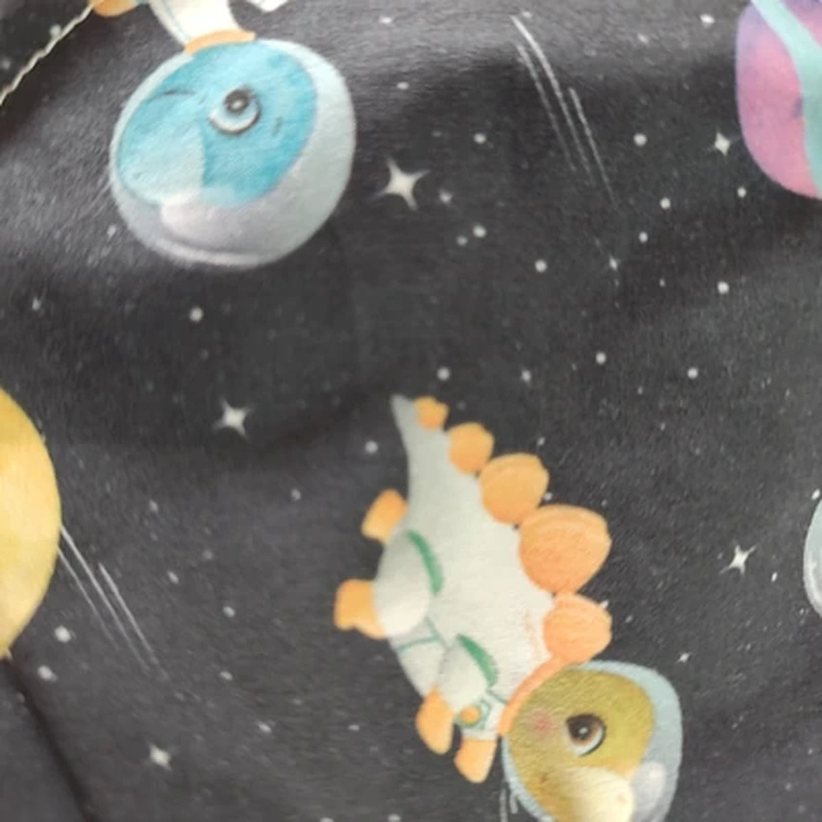 Detalle del estampado Dinosaurios del espacio sobre tela de algodón