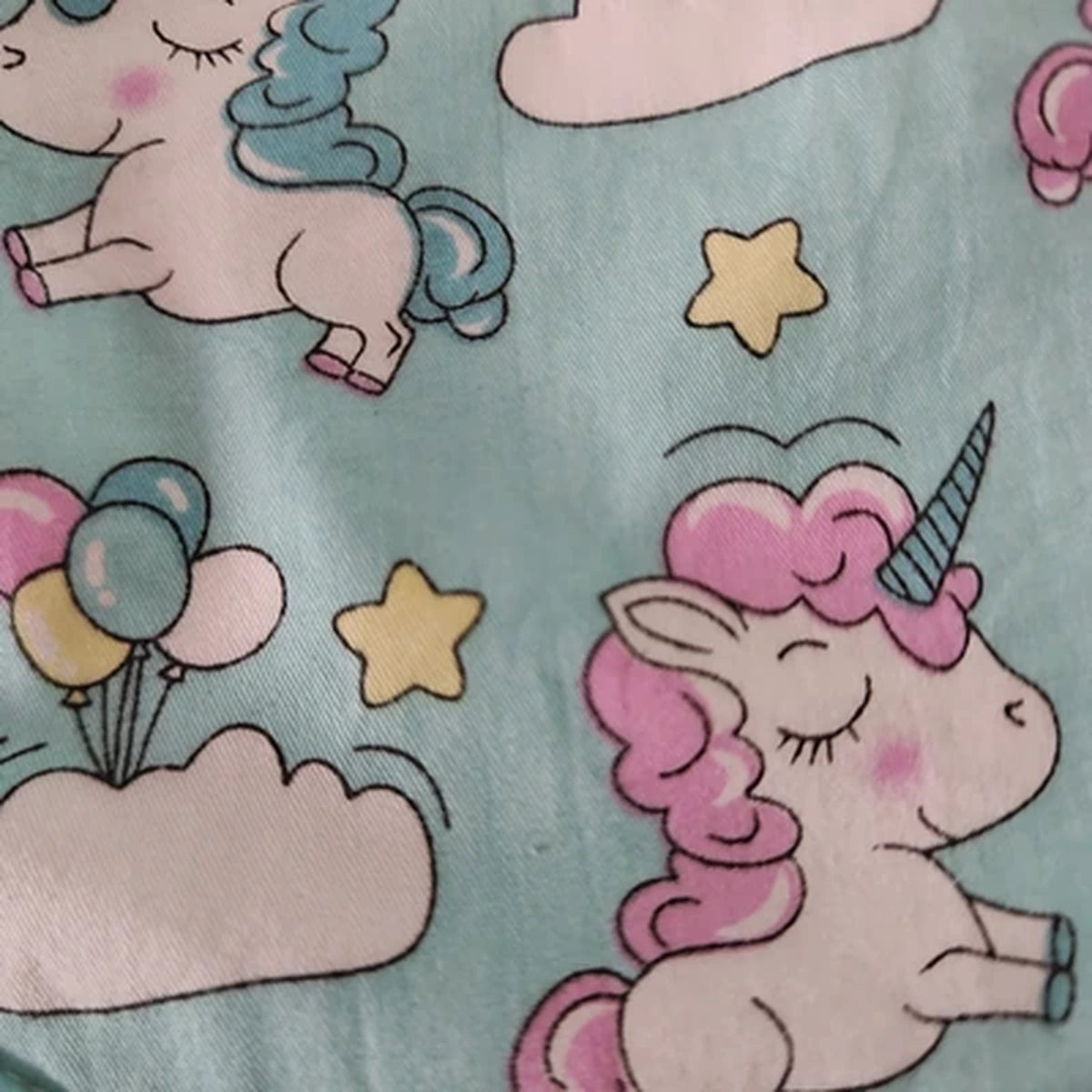 Detalle del estampado Unicornios entre nubes sobre tela de algodón